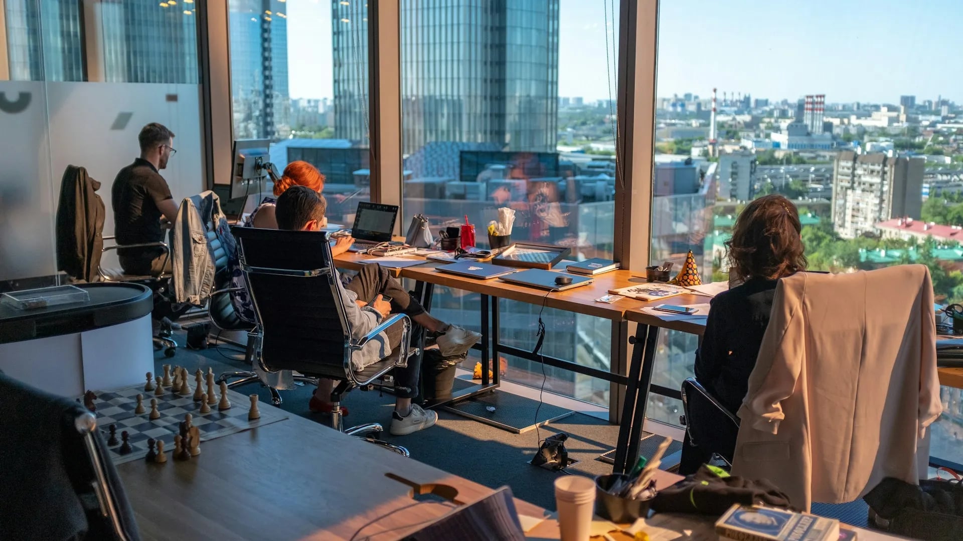Team working in a modern office with large windows overlooking the city skyline.