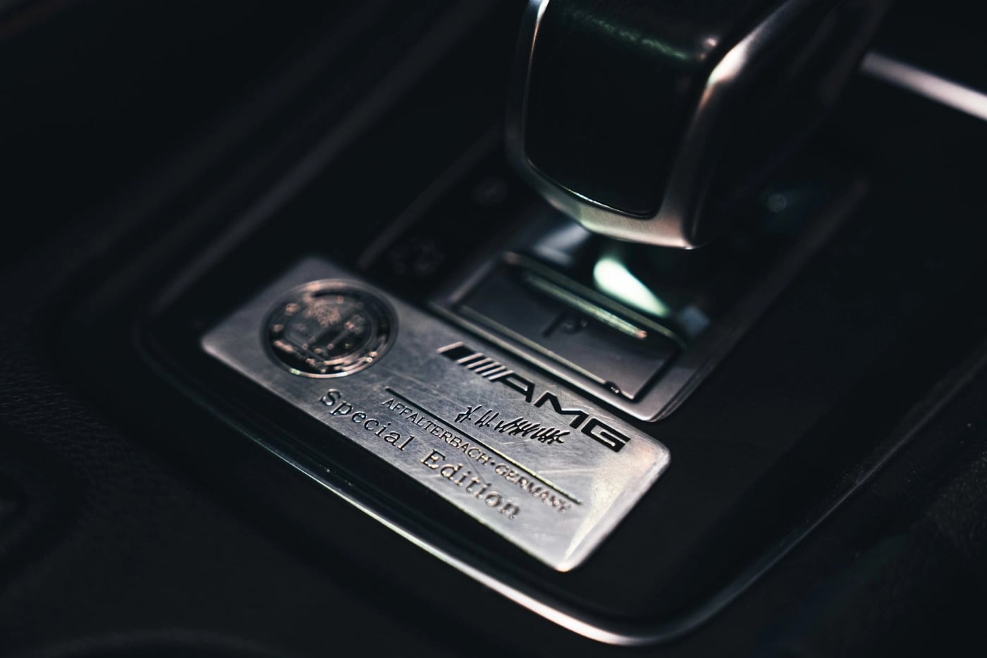 Close-up of a car gear selector with a metal AMG Special Edition badge, representing precision engineering and premium design.