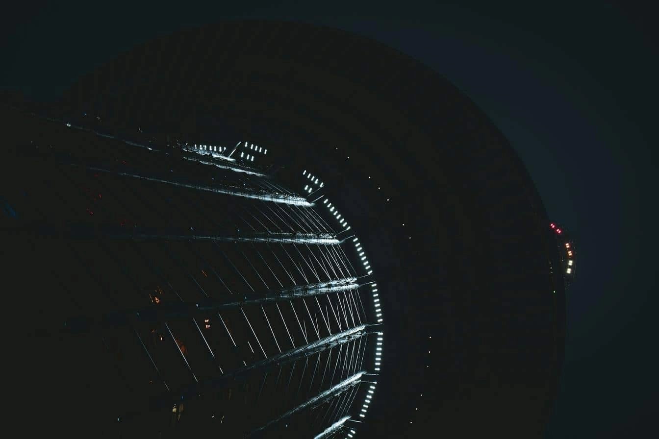 Upward view of a modern lit skyscraper symbolising scalability, growth and infrastructure.