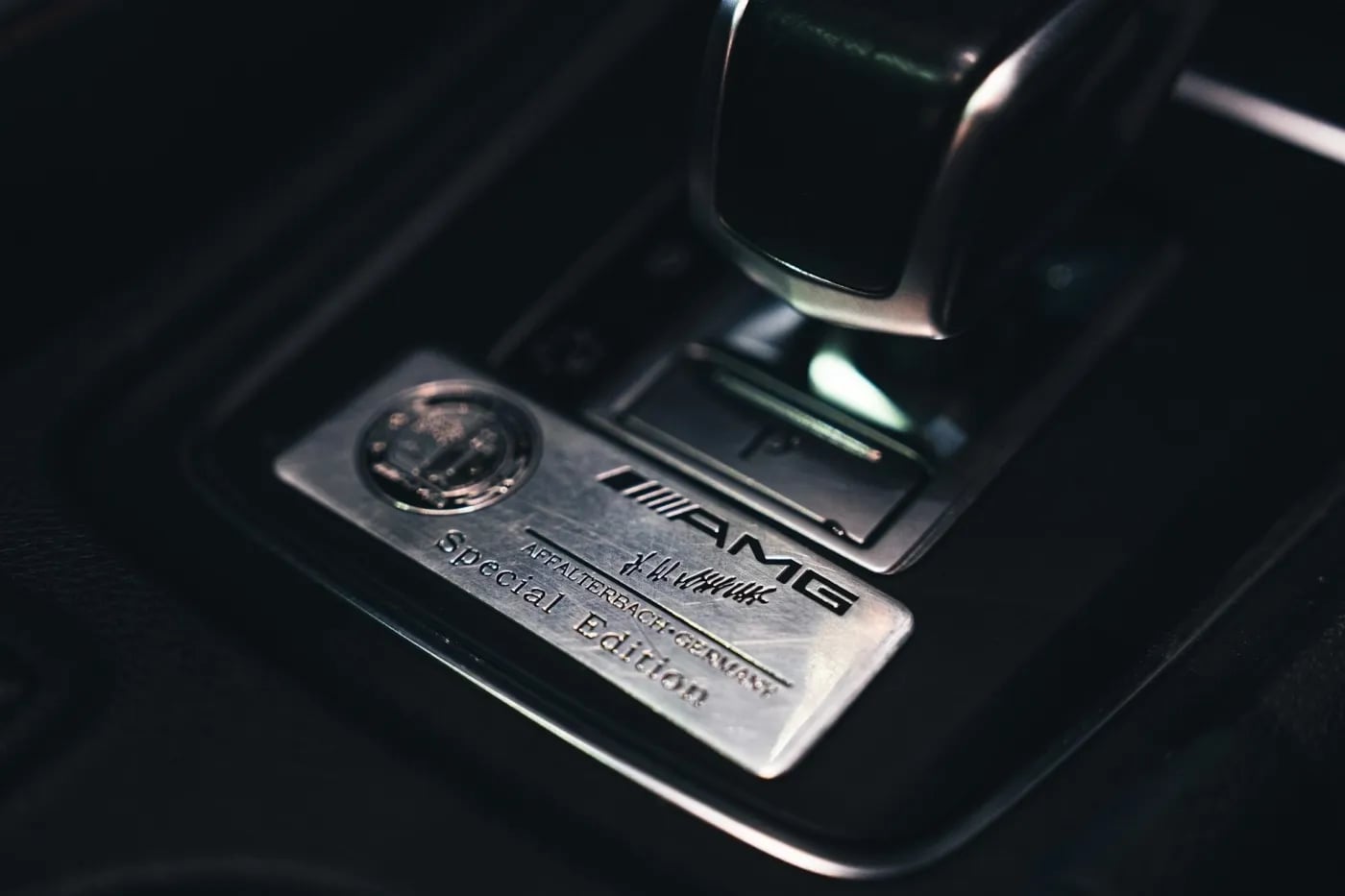 Close-up of a car gear selector with a metal AMG Special Edition badge, representing precision engineering and premium design.