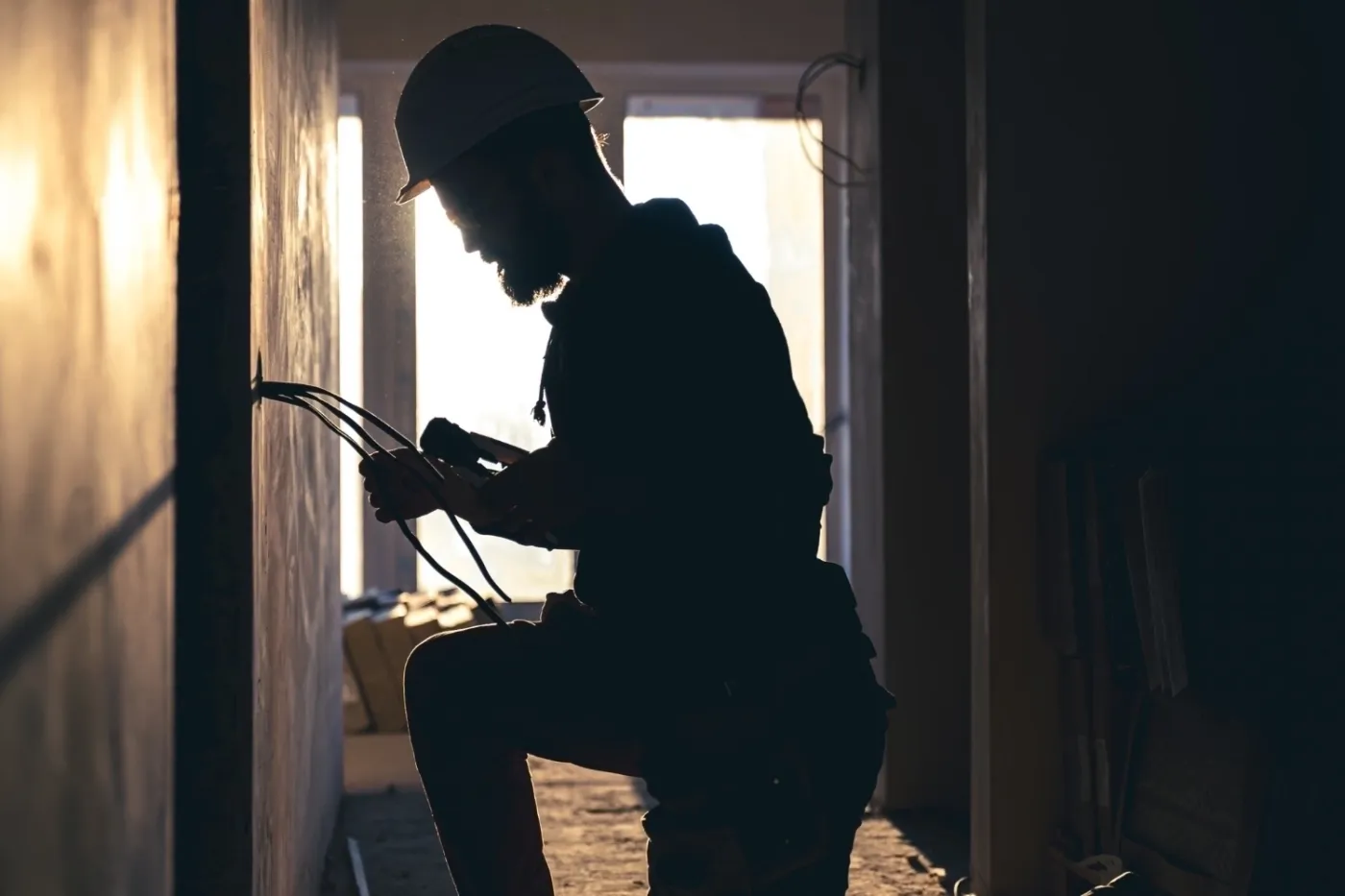 Electrician working on wiring during building construction.