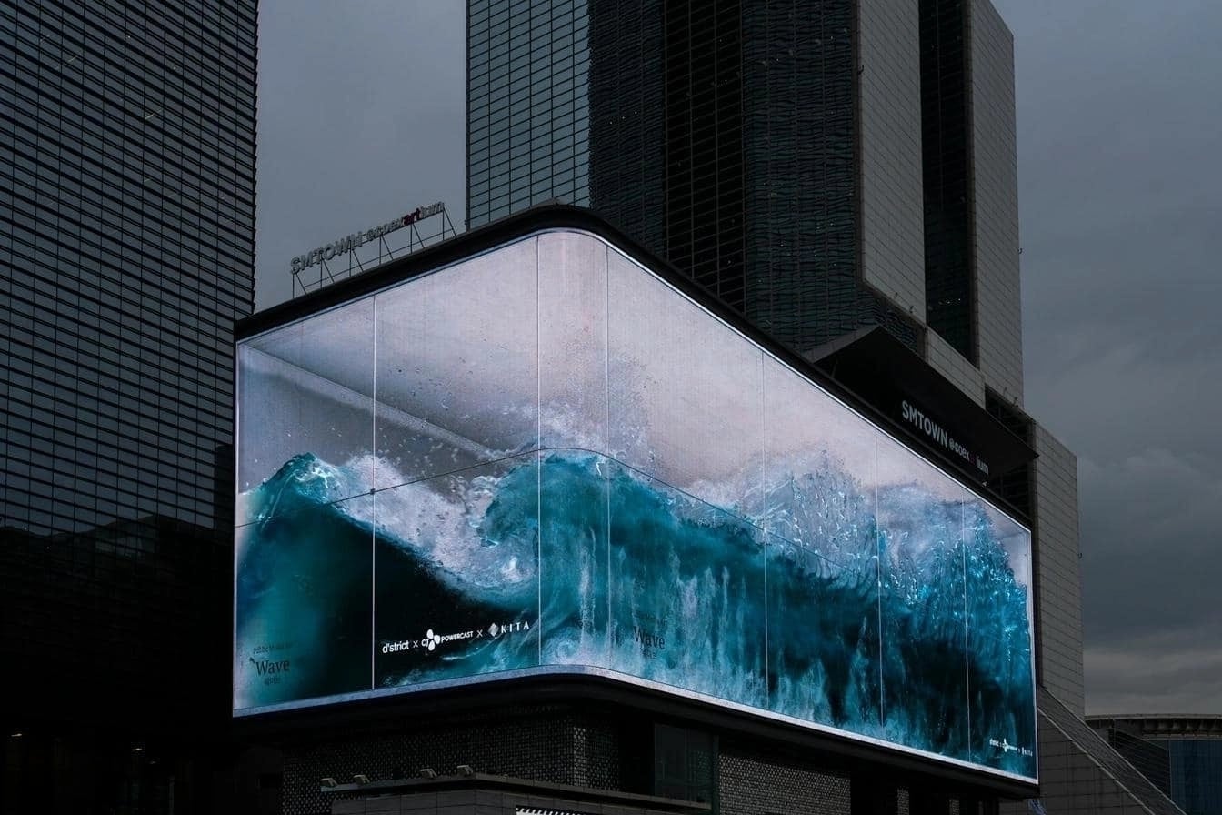 Digital 3D billboard displaying a dynamic ocean wave in a cityscape.