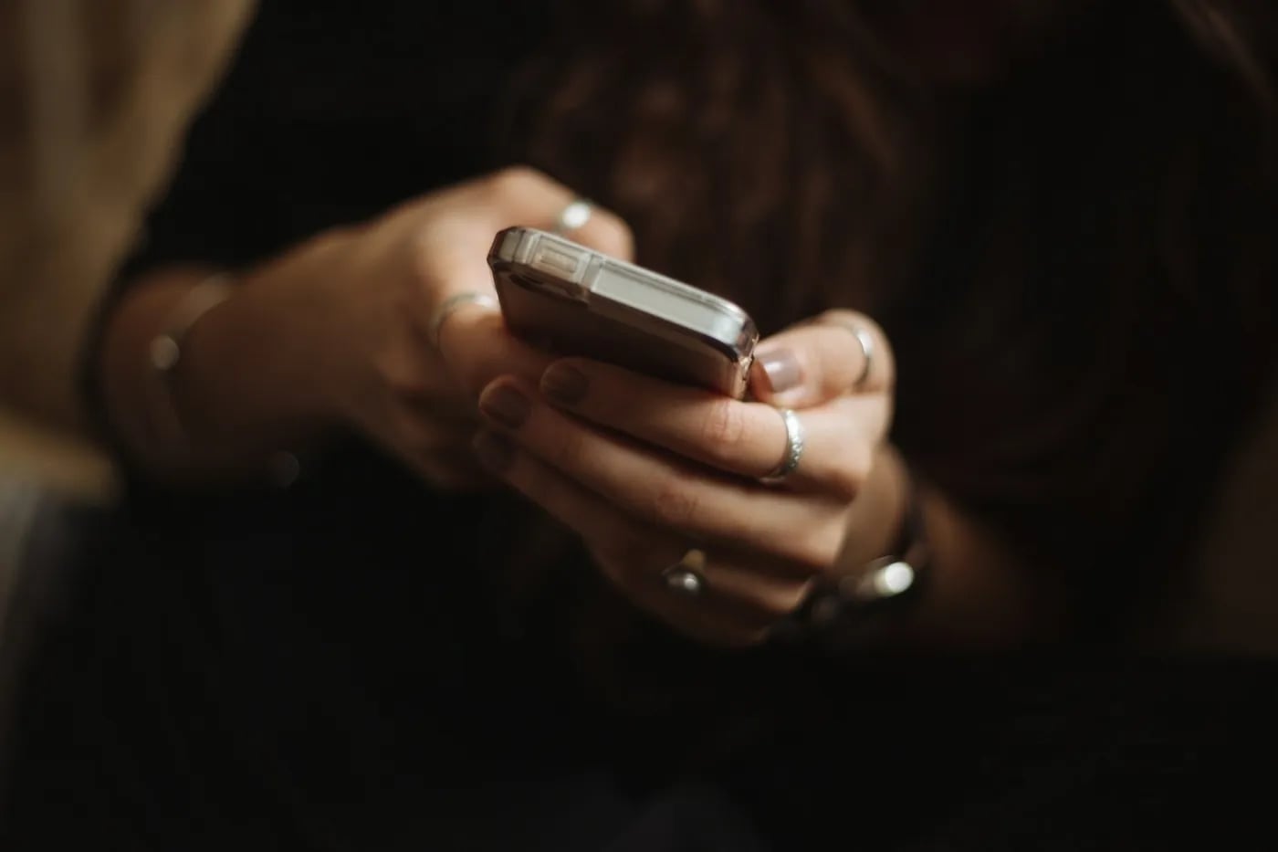 Close-up of a woman’s hands holding and typing on a smartphone