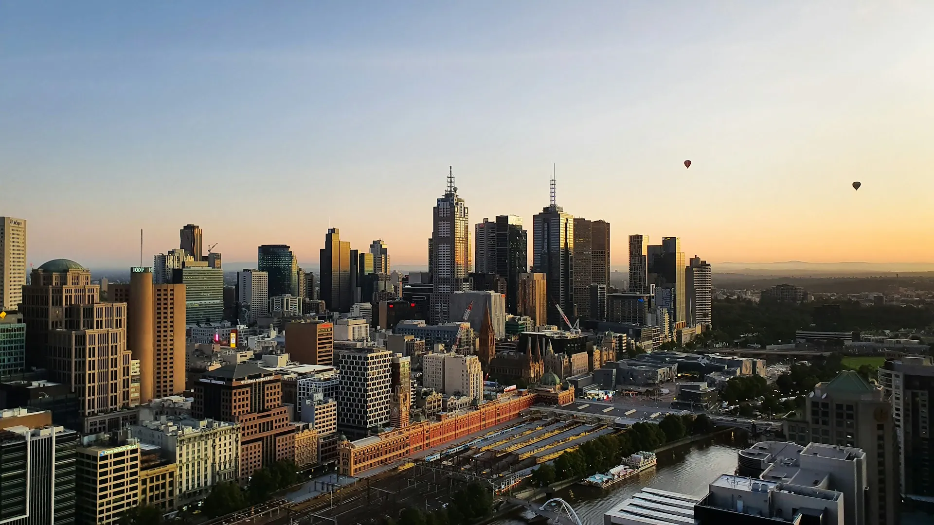 Three-panel view of Melbourne cityscape at sunrise, featuring high-rise buildings, Flinders Street Station, and hot air balloons over the skyline.